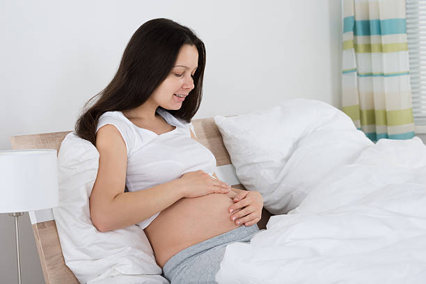 istock Expecting Woman Sitting On Bed 584210986