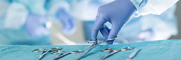 primo piano di strumenti medici scrub infermiera prendendo - apparecchiatura chirurgica foto e immagini stock