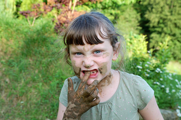 istock girl with muddy hands 584211856