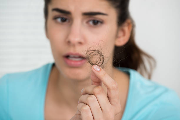istock Woman Looking At Hair Loss 584212184