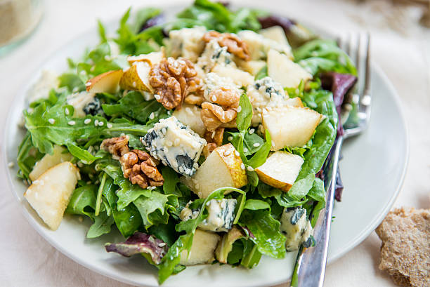 Green Salad with Pears, Blue Cheese, Walnuts Healthy Salad made from Green Salad Leaves, Rocket Salad, Slices of Fresh Pears, pieces of Blue Cheese, Walnuts and Sesame Seeds. Pieces of Pita Bread nearby blue cheese stock pictures, royalty-free photos & images