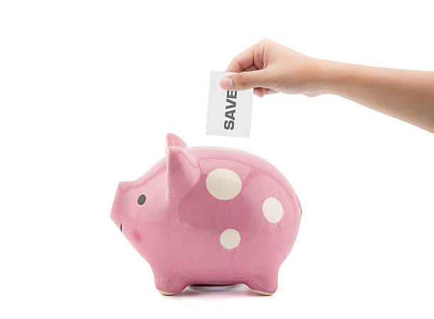 istock hand putting a save into a pink piggy bank 584215414