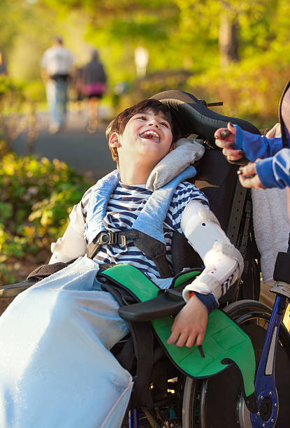 istock Young disabled boy in wheelchair looking up into sky 584218794