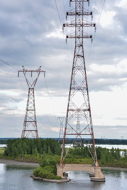 istock Electrical towers run along a river bank 584224440