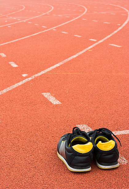 istock Sport shoes on running track background 584225540