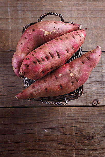 Red Sweet potato over rustic wooden background stock photo