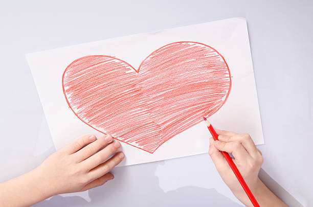 istock childs hands drawing a red heart 584227438