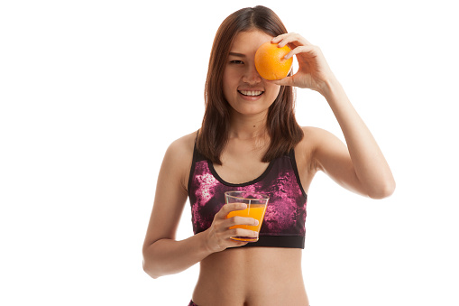 Beautiful Asian healthy girl with orange juice and orange fruit isolated on white background.