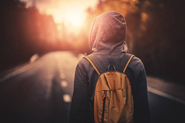 istock Traveler walking alone in the forest at sunset 584230042