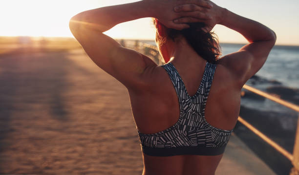 mujer musculosa en sujetador deportivo al atardecer - sostén deportivo fotografías e imágenes de stock