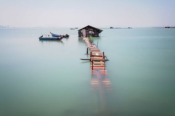 istock Water overflow on a broken wooden bridge and a hut 584231216
