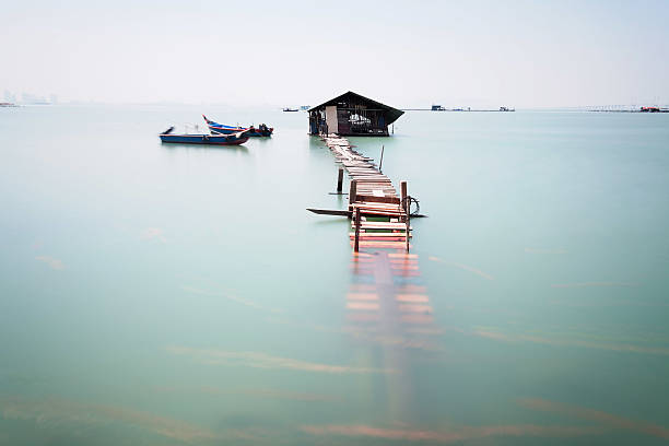 istock Water overflow on a broken wooden bridge and a hut 584231380