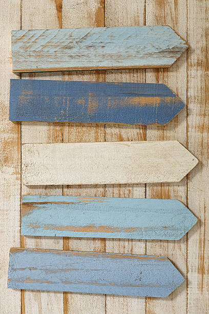 istock Old weathered blue and white wood sign arrows. 584231438