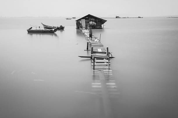 istock Water overflow on a broken wooden bridge and a hut 584231876
