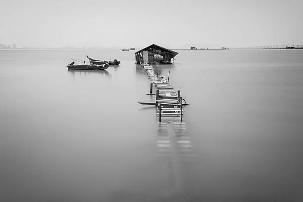 istock Water overflow on a broken wooden bridge and a hut 584231956