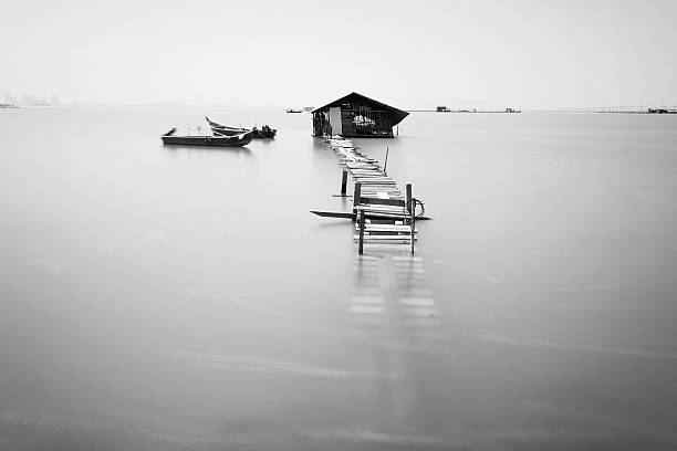 istock Water overflow on a broken wooden bridge and a hut 584232120