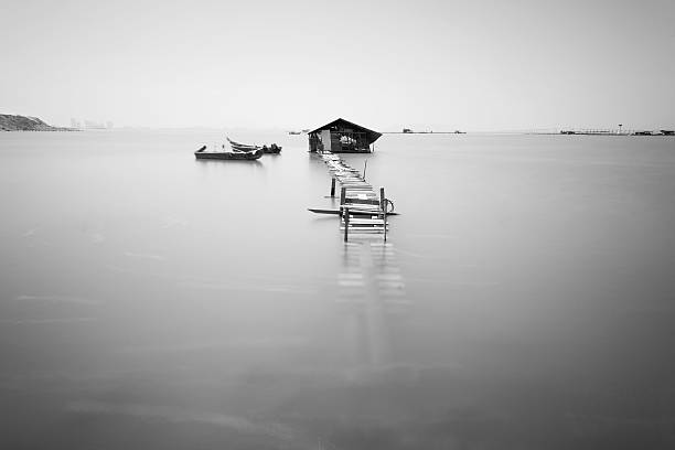 istock Water overflow on a broken wooden bridge and a hut 584232140