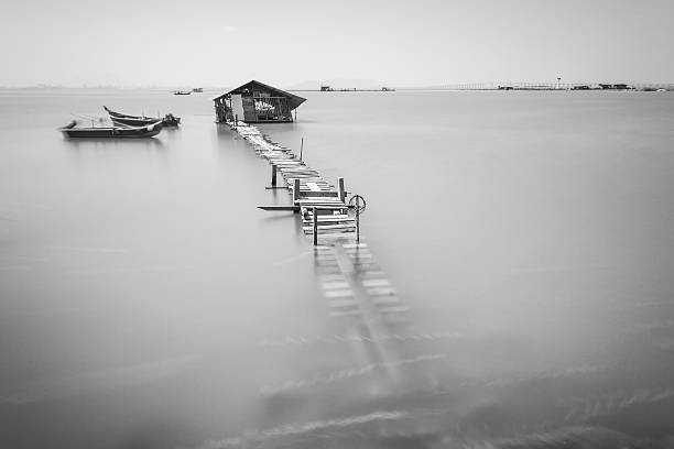 istock Water overflow on a broken wooden bridge and a hut 584232172