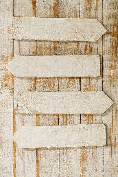 istock Old weathered white wood sign arrows. 584232632