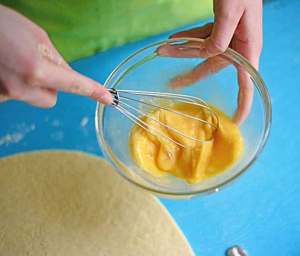 istock Female hand beating eggs closeup 584232758