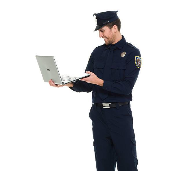 istock Smiling police working on laptop 584232878