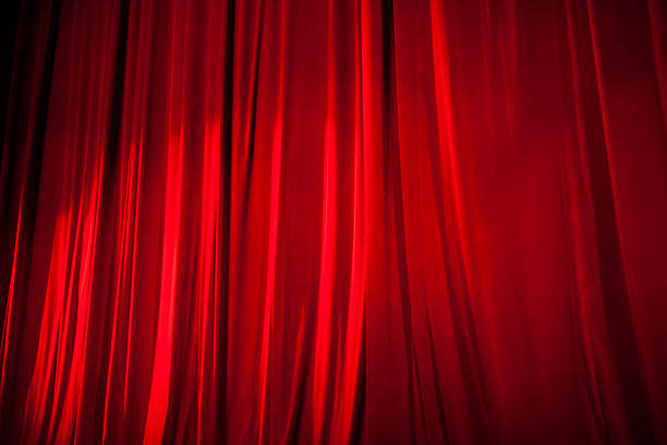istock Light Shining on the Red Stage Curtain 584233574