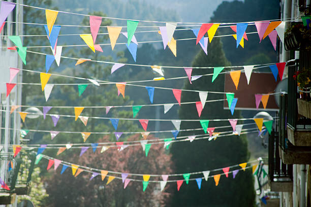 Street multicolored feast decorations in the sunlight. trees in the background. 