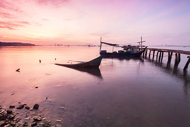 istock Shore with silhouette of broken boat and rock texture 584236208