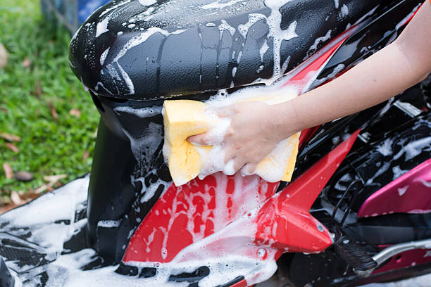 istock Female hand with  yellow sponge  washing a motorcycle. 584238206