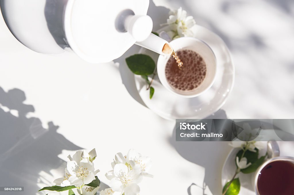 Top view of tea pot flow of tea in the Top view of tea pot flow of tea in the garden. Healthy lifestyle. Sunlight. Afternoon Tea Stock Photo