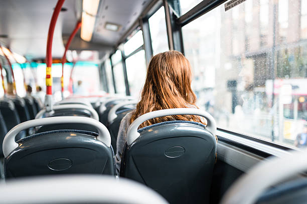 femme à l’intérieur d’un bus à londres voyage seul - vehicle seat photos et images de collection