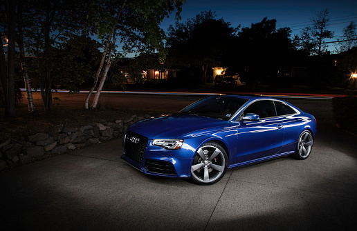 Halifax, Nova Scotia, Canada - June 20, 2016: An Audi RS5 parked in a driveway at night.  Light panted image with streak of light in background from car passing on street.