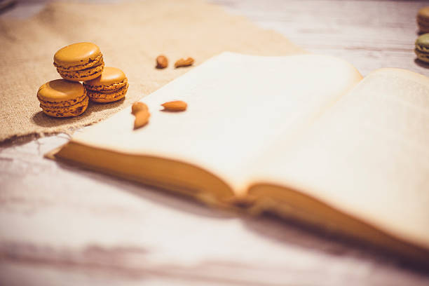 Macaroons cookies and book on wooden rustic table