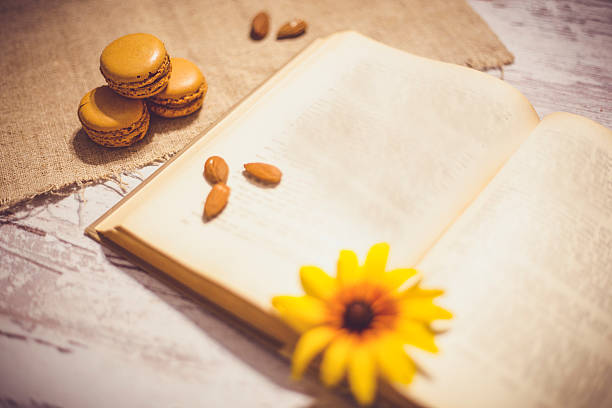 Macaroons cookies and book on wooden rustic table