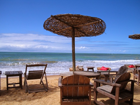 A view of Trancoso Beach, nearby Porto Seguro, Bahia, Brazil, South America. At the background ths blue sky can be seen, just above the green sea.