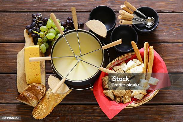 Traditional Set Of Utensils For Fondue With Bread Cheese Grapes Stock Photo - Download Image Now