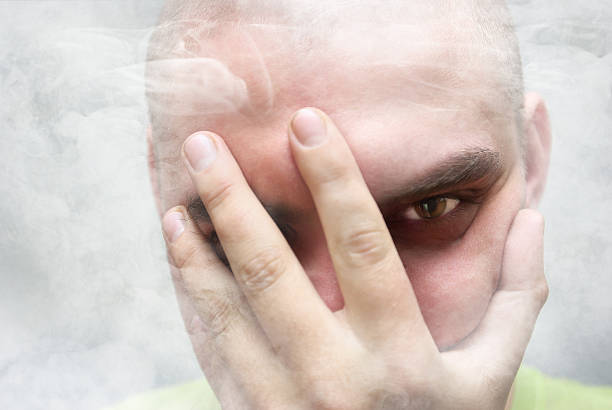 istock man covers his face from the smoke 584468368