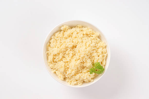 bowl of cooked couscous on white background