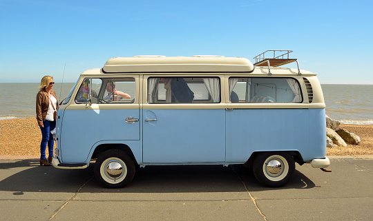 Felixstowe, Suffolk, England - May 01, 2016:  enthusiasts admiring Classic Blue and white Volkswagen camper van parked on Felixstowe seafront promenade.