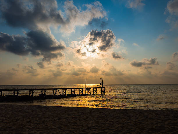 istock Wooded bridge to the sea between sunset 584471912