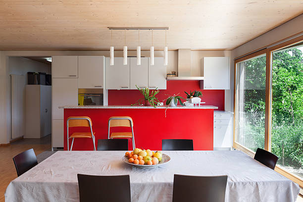 Interior, dining table and kitchen Interior of an eco house, dining table and kitchen red kitchen cabinets stock pictures, royalty-free photos & images