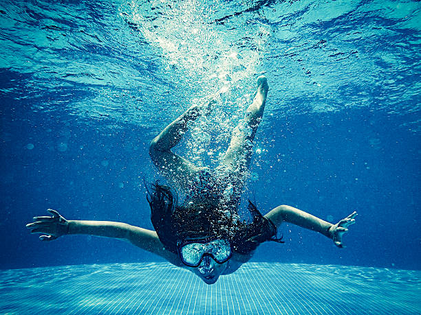 istock Girl diving underwater 584473198