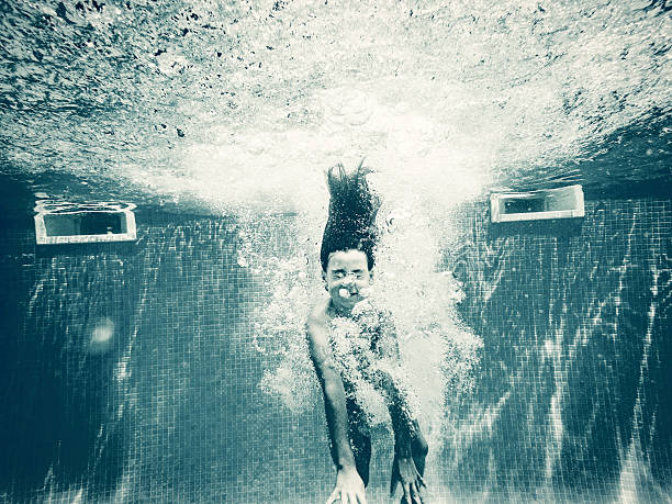 istock Girl diving underwater in swimming pool 584473218