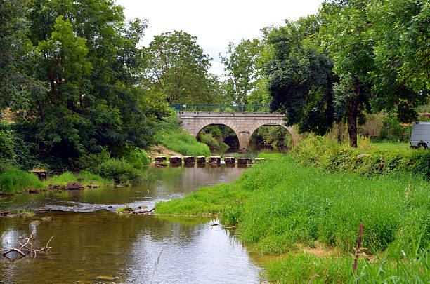 istock stone bridge at a river in south france 584475106
