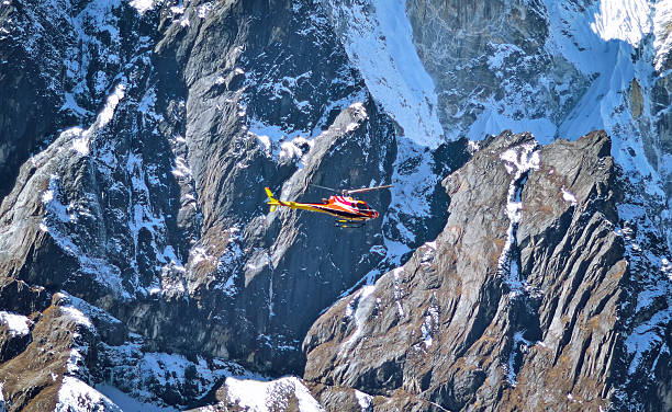 istock Helicopter is flying between snow mountains peak 584476506