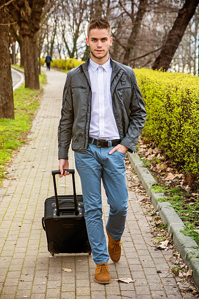 istock Man with baggage standing on pavement near river 584476508