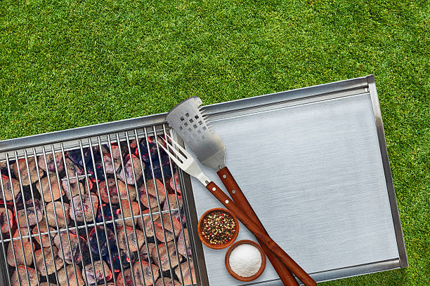 BBQ Grill Glowing Charcoal Briquettes Salt Pepper Utensils Grass Background