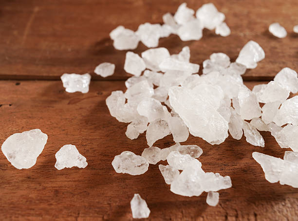 istock Closeup white sea salt on wooden table 584479186