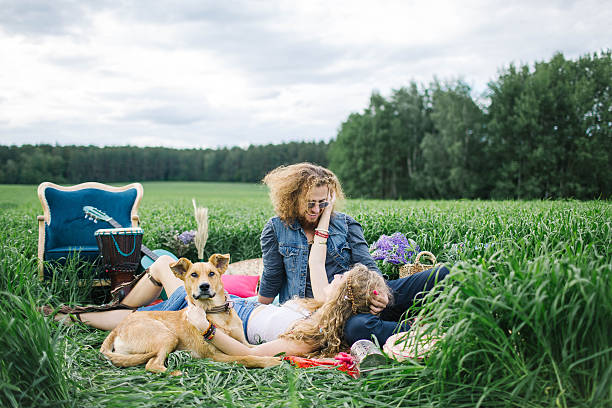 istock Young beautiful hippie couple lying on grass having fun 584481996