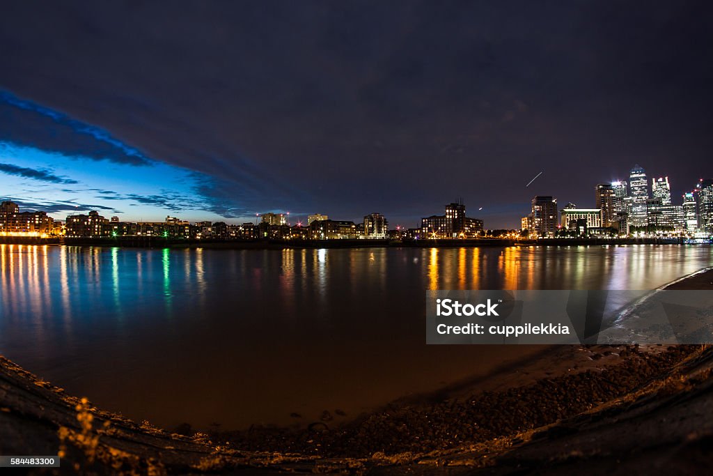 London River cityscape at sunset View of the Thames river in London at sunset, skyline of the city buildings in Canary Wharf from Canada Water Architecture Stock Photo